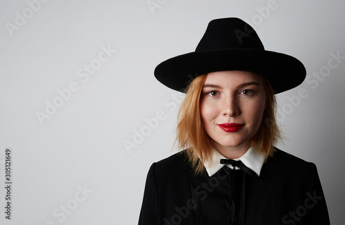 Portrait of hipster girl wearing black dress and hat. Isolated and space for text. photo