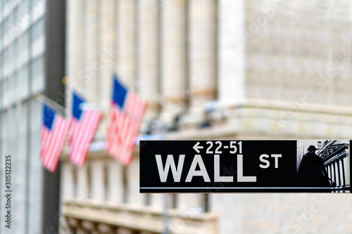 Wall street sign in New York city financial economy and business district with America national flag background. Stock market trade and exchange zone. photo
