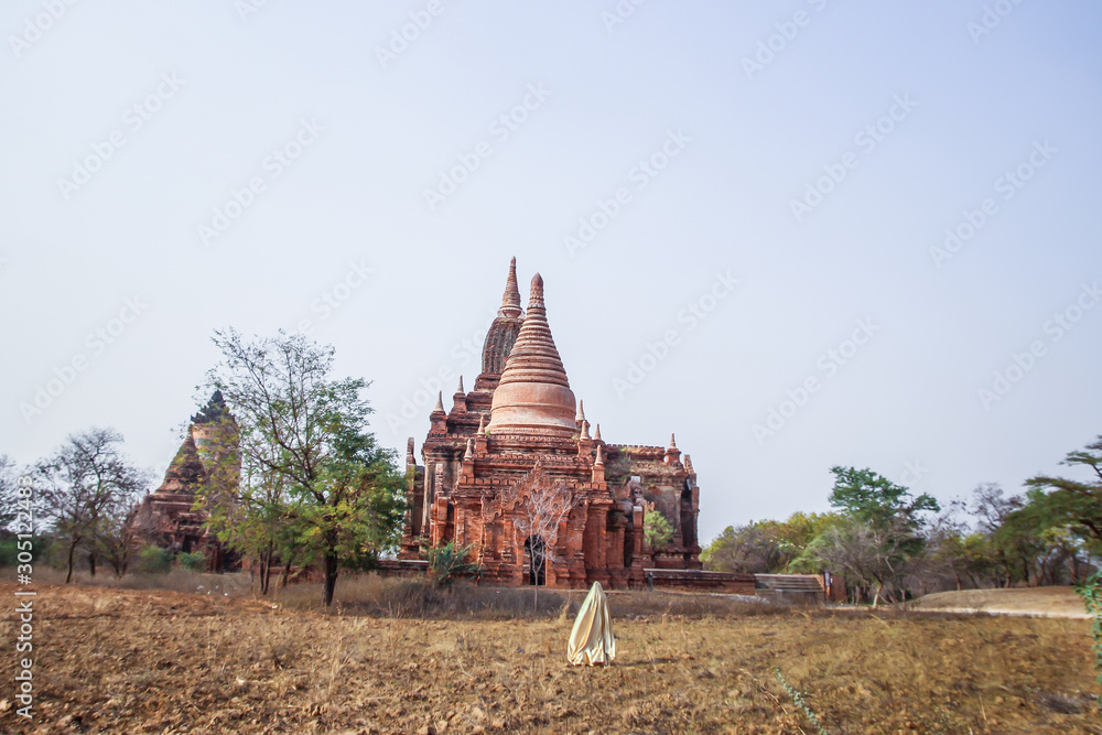 Creature in a gold floaty robe walking along ancient Myanmar Buddhist temples and stupas experimental shoot