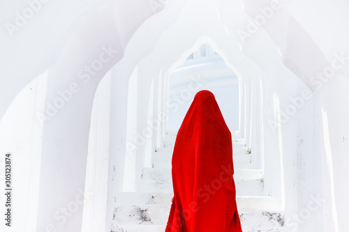 Creature in a red floaty robe walking along ancient Myanmar Buddhist temples and stupas experimental shoot