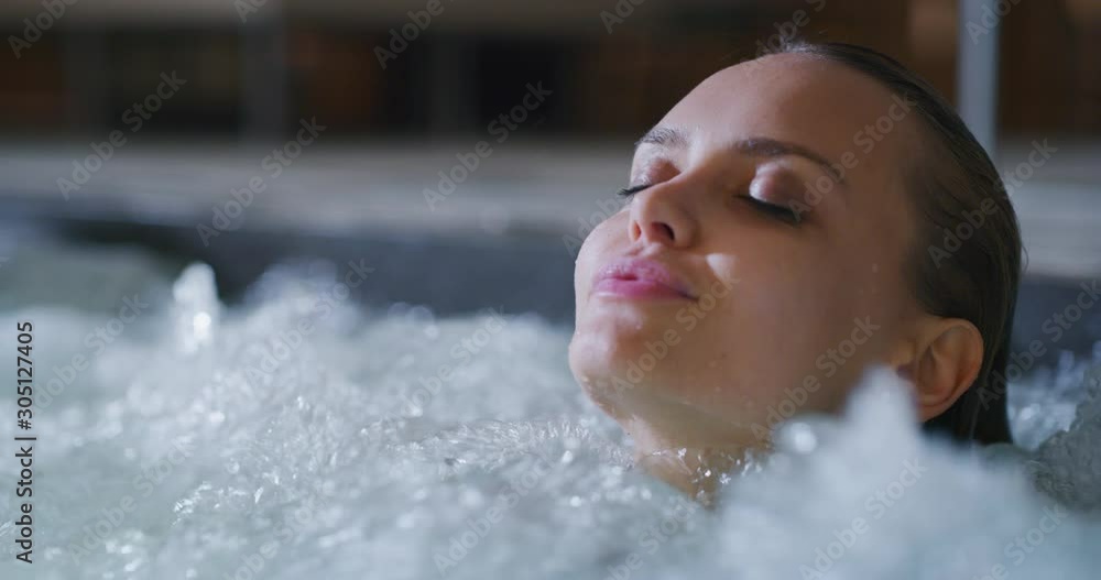 Close up of an young female is enjoying and having relax in a bath tube in a luxury wellness center. Close up of an young female is enjoying and having relax in a bath tube in a luxury wellness center.