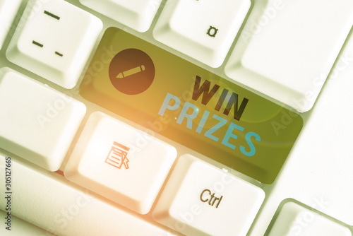Conceptual hand writing showing Win Prizes. Concept meaning something given for victory in a contest or competition White pc keyboard with note paper above the white background