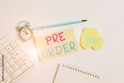 Word writing text Pre Order. Business photo showcasing an order for a product placed before it is available for purchase Copy space on empty note paper with clock and pencil on the table