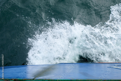 Starboard side of a ferry boat on the South China Sea being hit hard by waves in the evening.