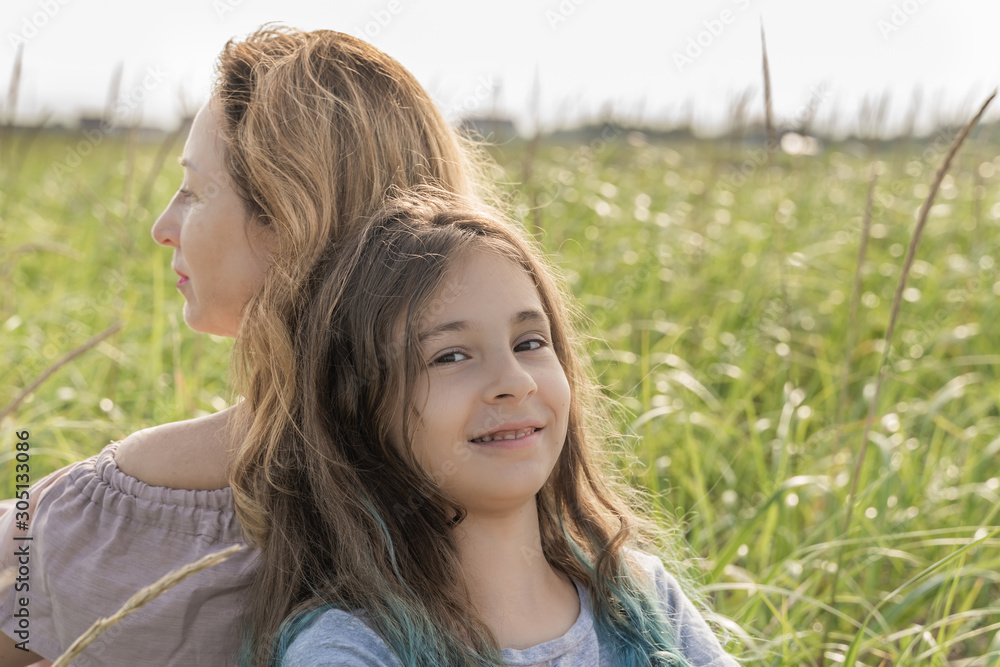 Happy mom and daughter spend time together on the meadow, Meditate, family concept. Happy mom and daughter spend time together on the meadow, Meditate, family concept.