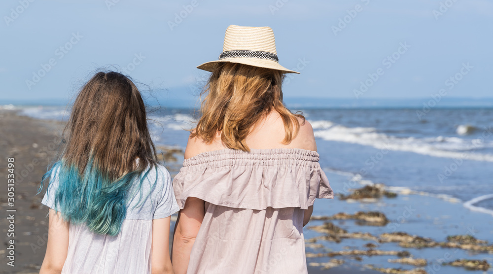 Happy mom and daughter spend time together at the seaside, family concept.