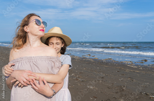 Happy mom and daughter spend time together at the seaside, family concept.