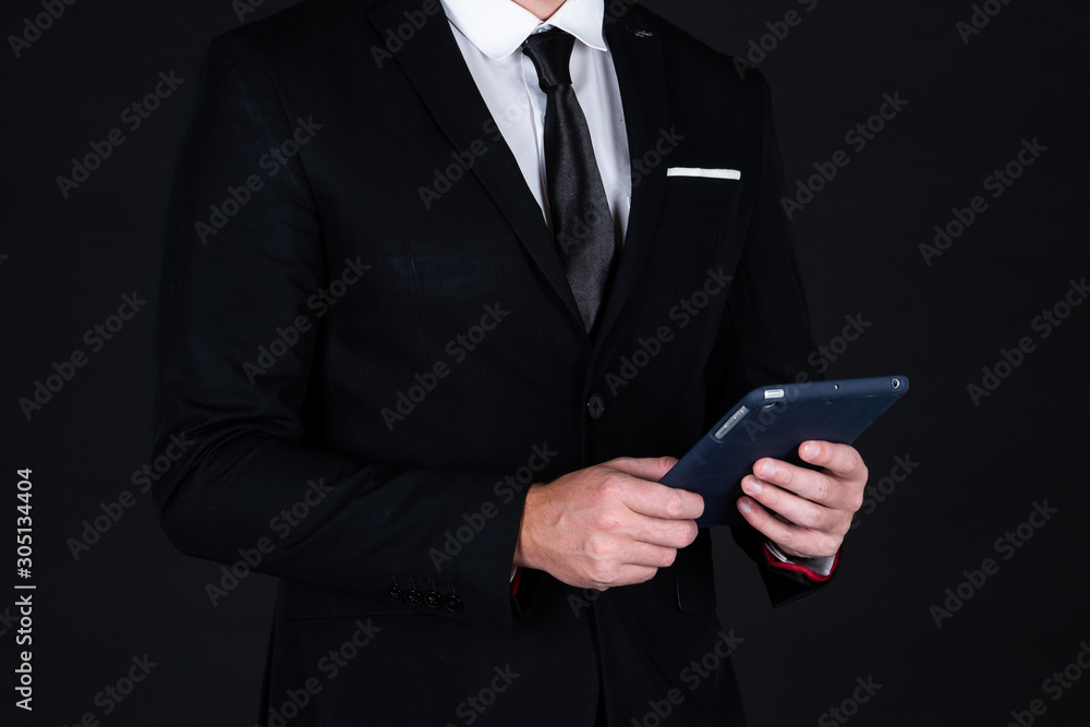 Confident businessman in black suit using technology on hand Confident businessman in black suit using technology on hand