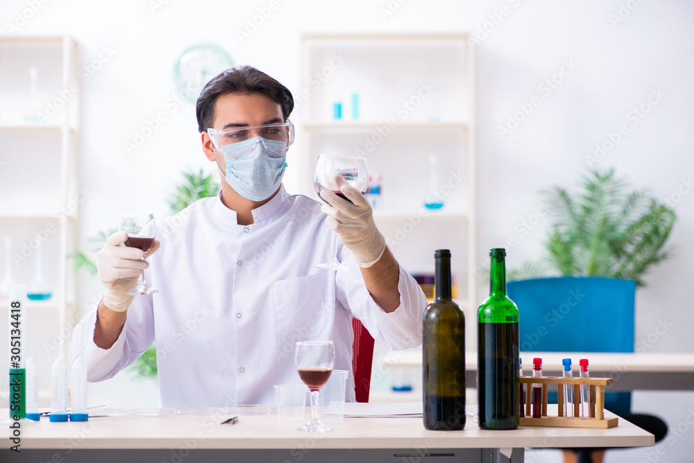 Male chemist examining wine samples at lab Male chemist examining wine samples at lab