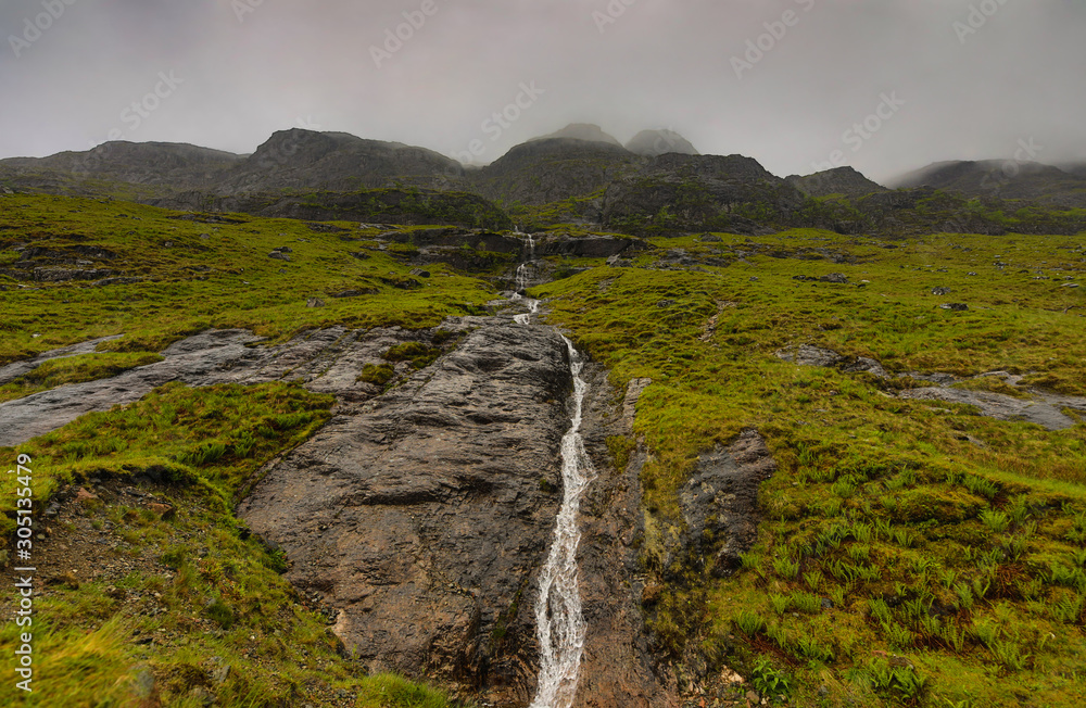 Picturesque landscape of a mountain waterfall and traditional nature of Scotland.