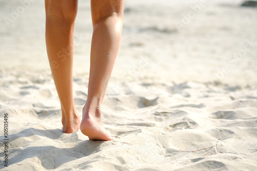 Feet and legs of women walking on Beach of the sea On weekends