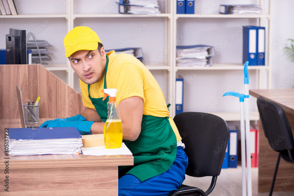 Young male contractor cleaning the office Young male contractor cleaning the office