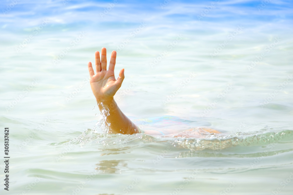 The man's hand drowned, he lifted his hand and asked for help from drowning at the sea.