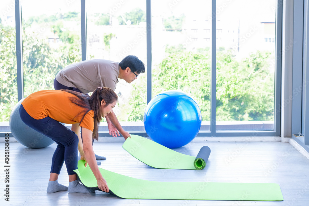 Elderly men and women are laying yoga mats for exercise Elderly men and women are laying yoga mats for exercise
