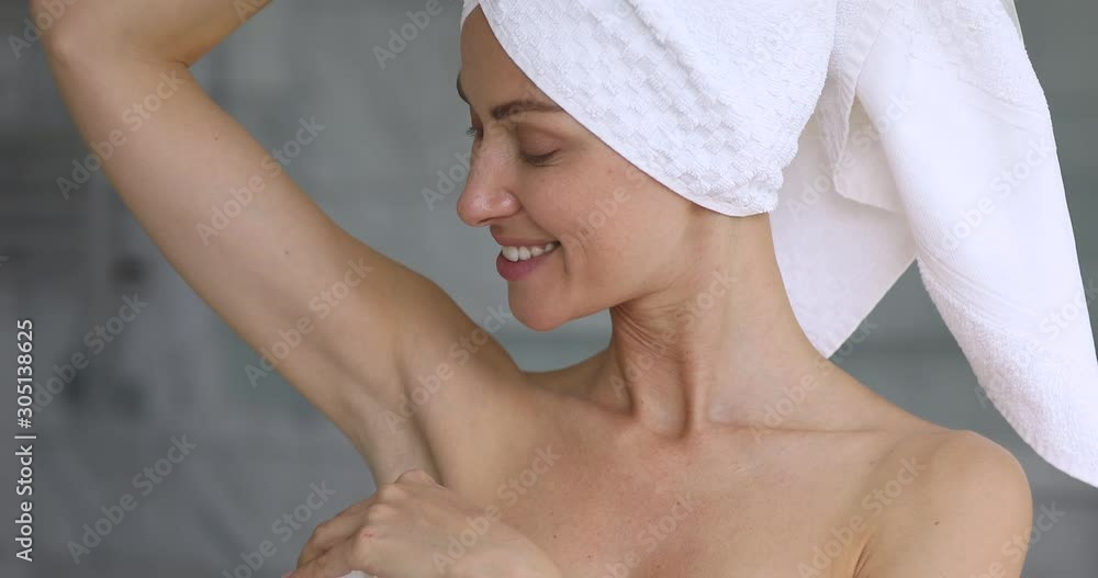 Attractive happy young woman apply antiperspirant in armpit Attractive happy young woman apply antiperspirant in armpit
