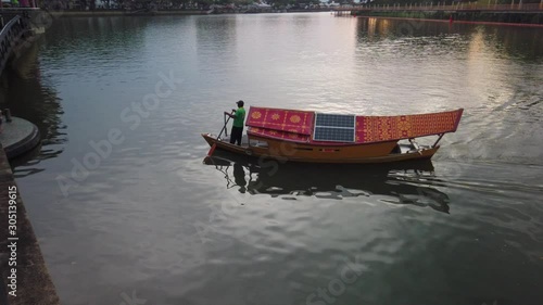 cinematic shot of boats carrying passenger across sarawak river in Kuching Waterfront.  photo