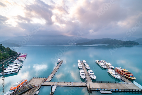 Tourist boats docking in peachful morning at Shuishe Pier, Sun Moon Lake, Taiwan.	 photo
