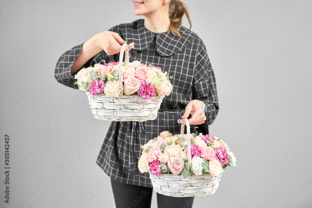 Two Flowers arrangements in Wicker basket. Modern floral shop. Finished work of the florist. Cute bouquet of mixed flowers in womans hands. Delivery fresh cut flower from online store Two Flowers arrangements in Wicker basket. Modern floral shop. Finished work of the florist. Cute bouquet of mixed flowers in womans hands. Delivery fresh cut flower from online store