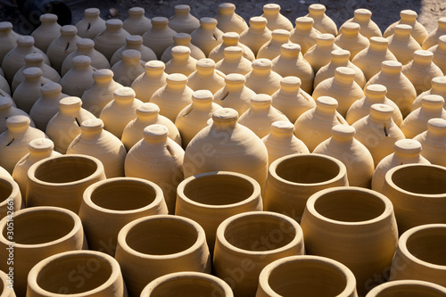 Traditional handmade clay pots slot product in lines together with sunlight and shadow background, Bahrain.