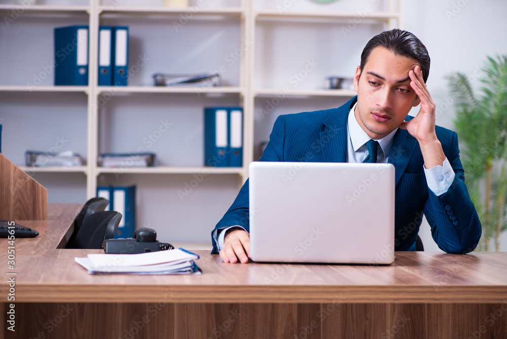 Fototapeta premium Young handsome businessman working in the office
