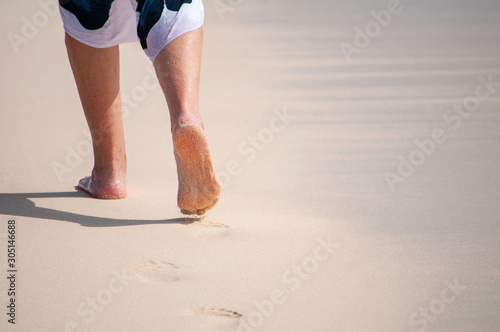 Person walking on the beach next to waves 