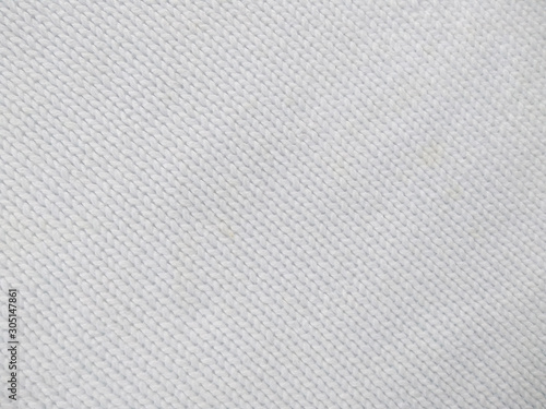 Background of wool yarn for yarn frame. White knitting yarn for handicrafts background. Knitted clothes from wool yarn.