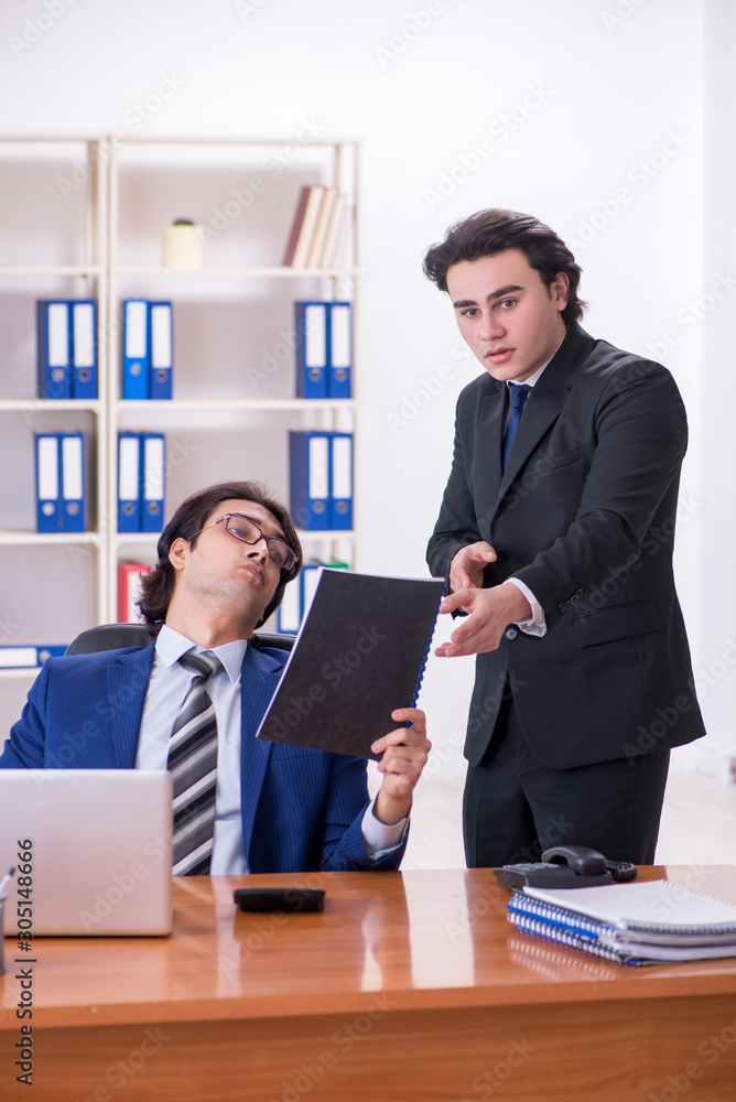 Boss and his male assistant working in the office Boss and his male assistant working in the office