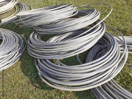 Aluminum electrical power cable on the meadow. Heavy aluminum wire for power supply.