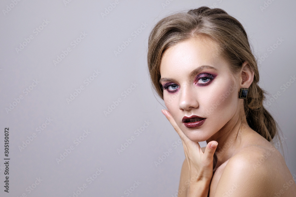 Naklejka premium beauty portrait of woman on gray background, fashion model with clean skin and beautiful lips, make up deep purple smokey eyes