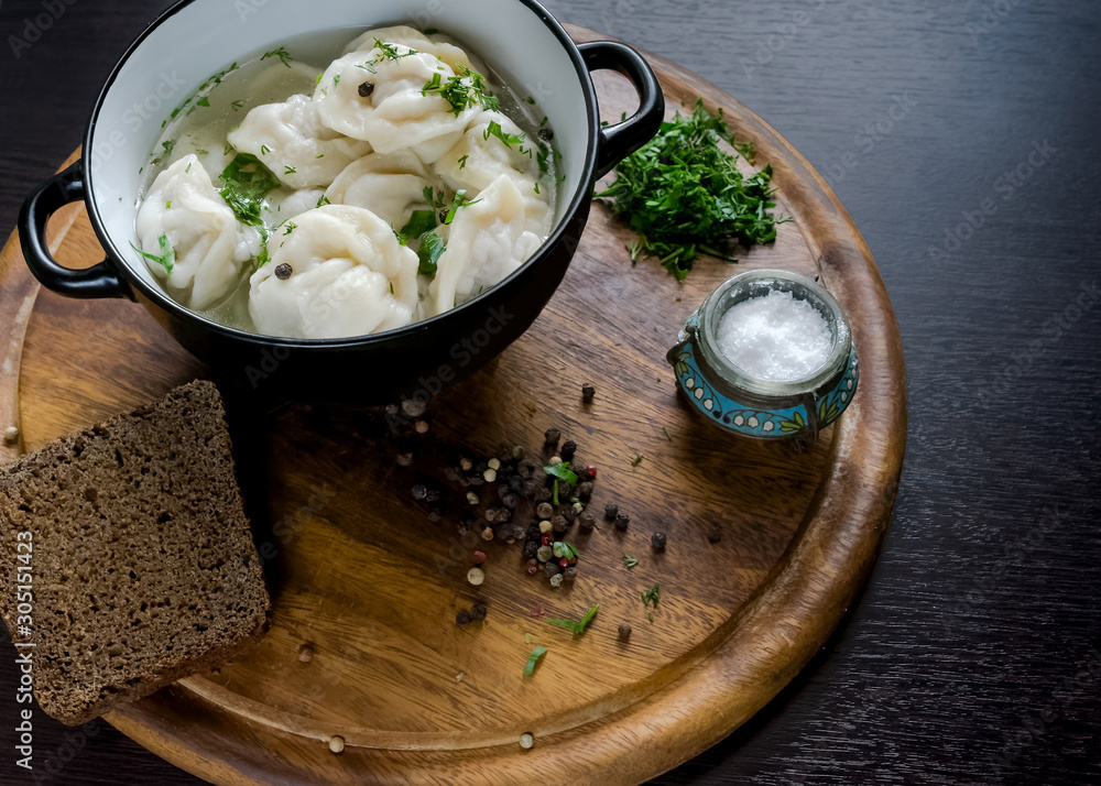 Russian dumplings with broth on a wooden tray Russian dumplings with broth on a wooden tray