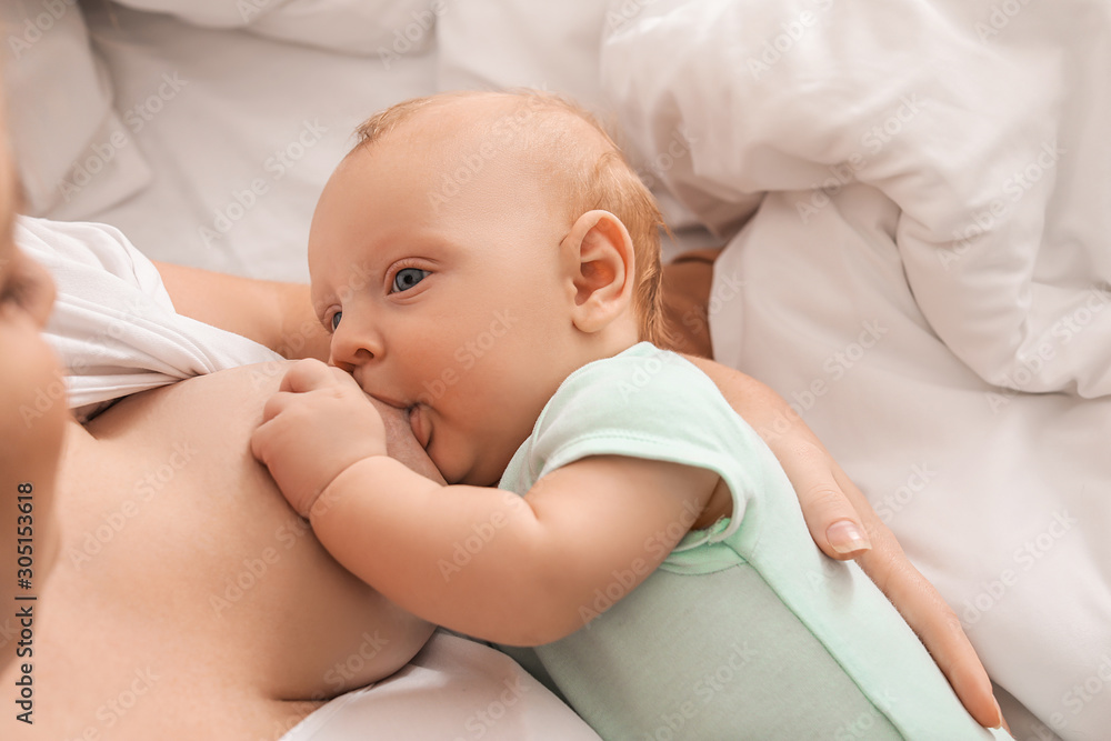 Young woman breastfeeding her baby at home, closeup Young woman breastfeeding her baby at home, closeup