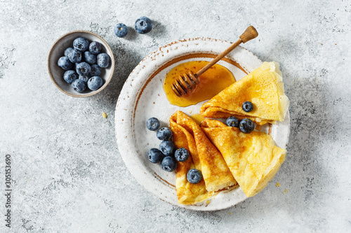 Crepes with honey and fresh blueberries. photo