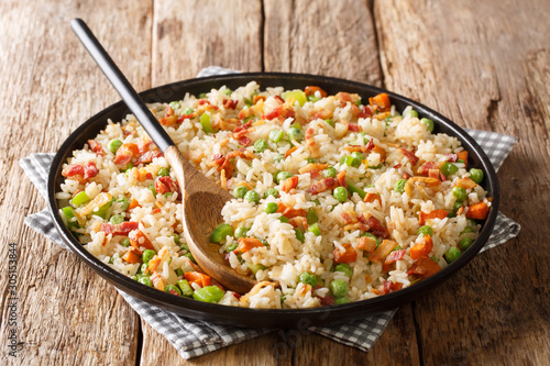 One pot of fried spicy rice with vegetables, herbs and bacon close-up in a plate. horizontal