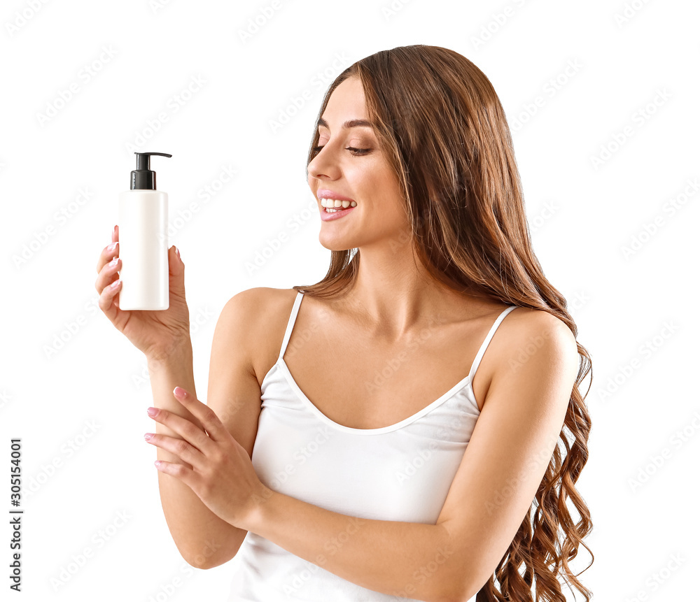 Beautiful young woman with bottle of cream on light background Beautiful young woman with bottle of cream on light background