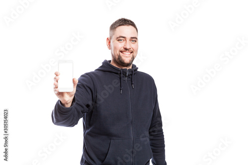 Cute smiling young man shows a phone with an isolated screen. Isolated over white background.