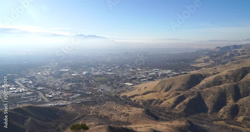 Upward pan of local Salt Lake City hills landscape with the downtown skyline and mountains in the background