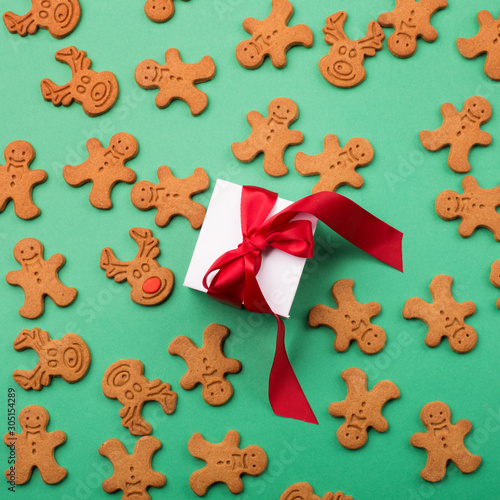 Gingerbread cookies and gift, green background