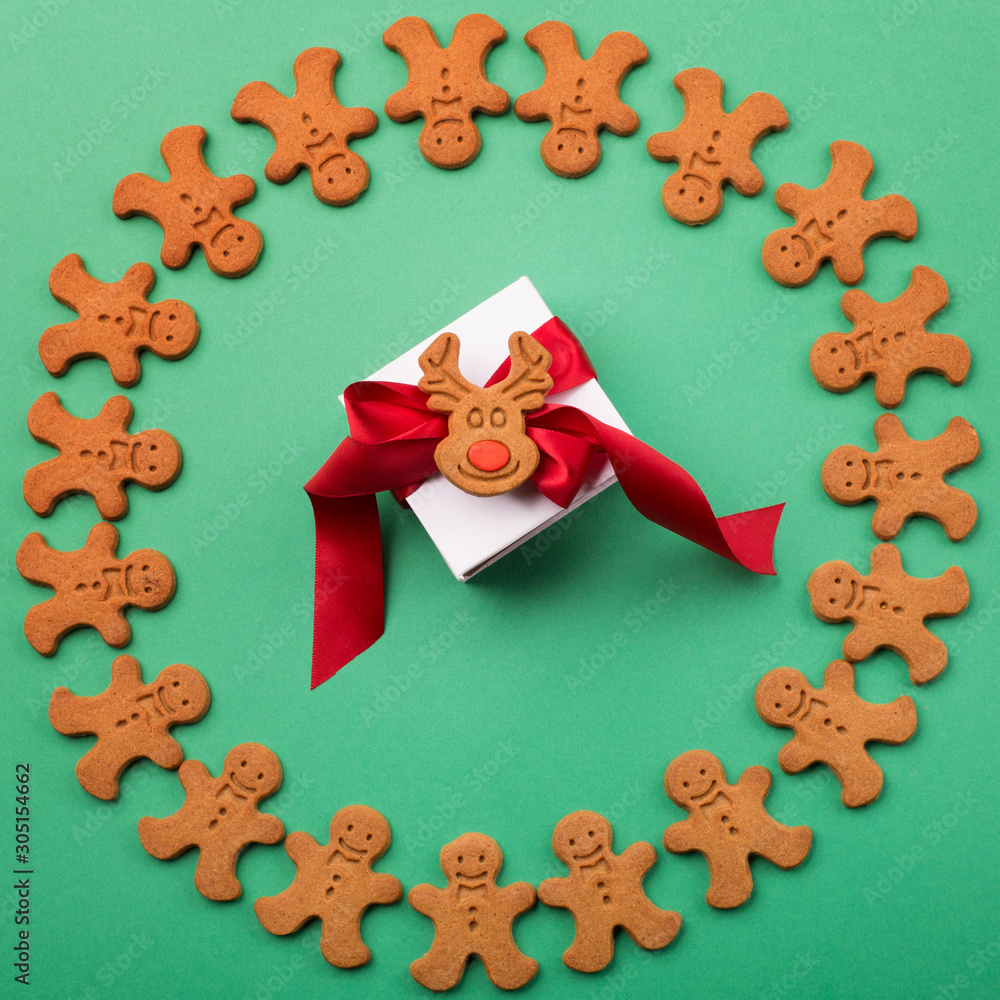Gingerbread cookies and gift, green background