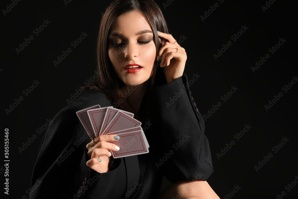 Beautiful young woman with playing cards on dark background Beautiful young woman with playing cards on dark background