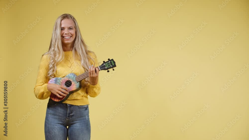 Talented Blonde Woman Singing while Playing the Ukulele Talented Blonde Woman Singing while Playing the Ukulele