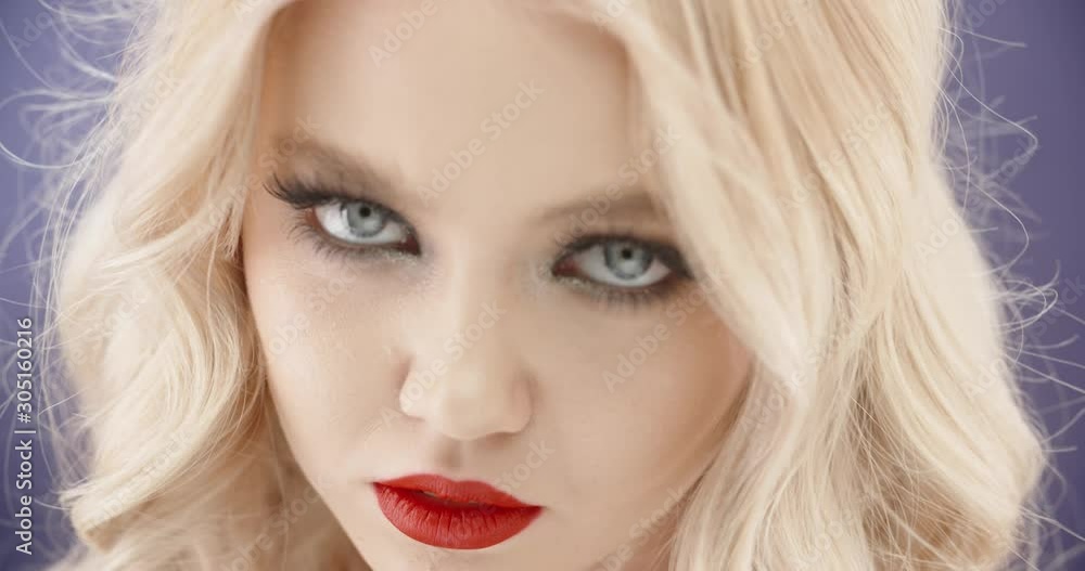 Sensual blonde caucasian girl with bright makeup looking at camera with seductive stare - close up shot 4k footage Sensual blonde caucasian girl with bright makeup looking at camera with seductive stare - close up shot 4k footage