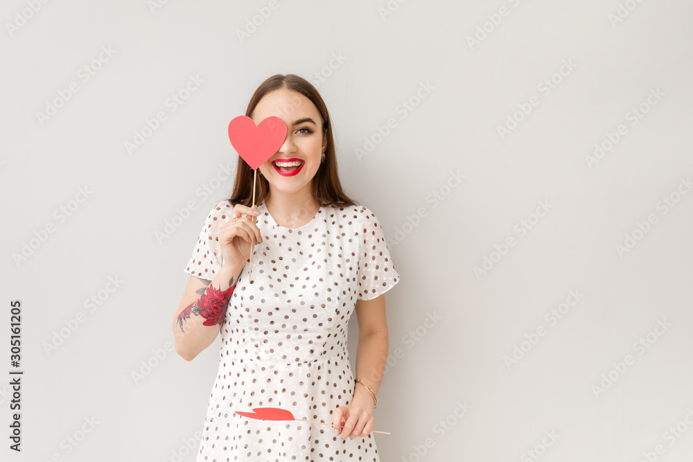 Beautiful young woman with red hearts on light background. Valentine's Day celebration Beautiful young woman with red hearts on light background. Valentine's Day celebration