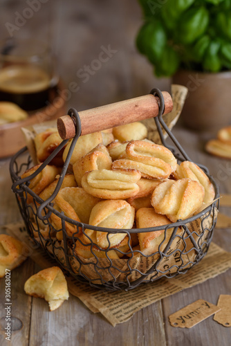 Foto Curd sugar cookies crow's feet in a metal basket on a wooden table