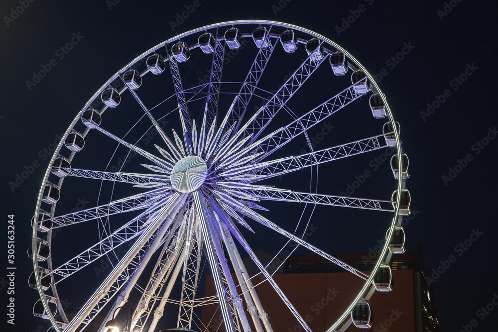 Bottom view of white ferris wheel at night. Blurred Ferris Wheel with black background