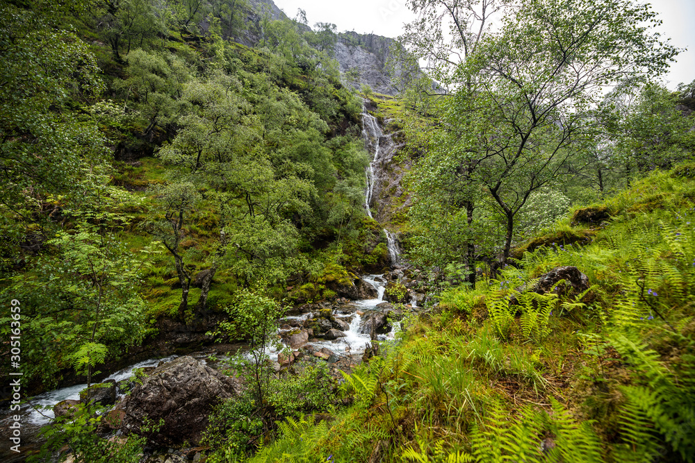 Picturesque landscape of a mountain waterfall and traditional nature of Scotland.