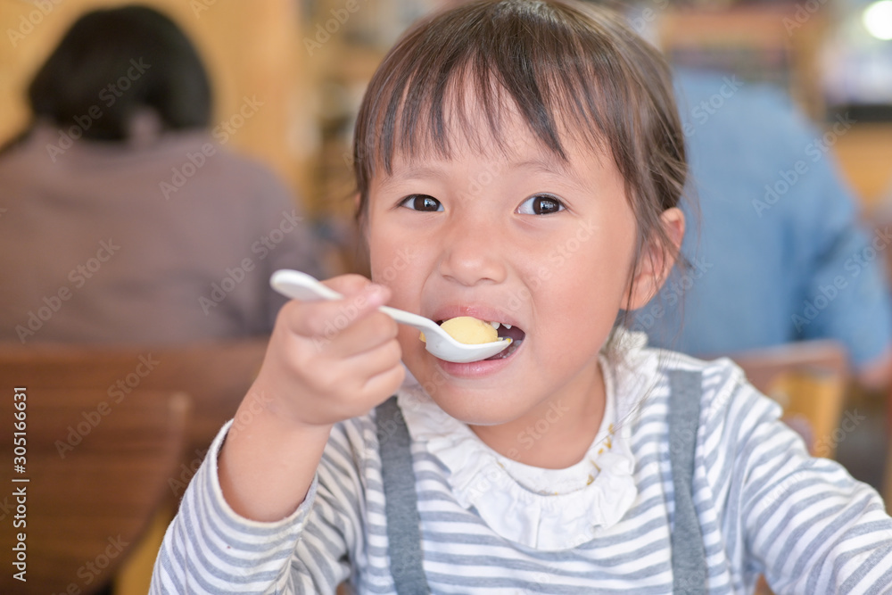 Little asian child girl having lunch on table in restaurant Little asian child girl having lunch on table in restaurant