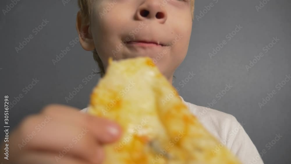 The boy is eating pizza. Unhealthy diet. Fast food home The boy is eating pizza. Unhealthy diet. Fast food home