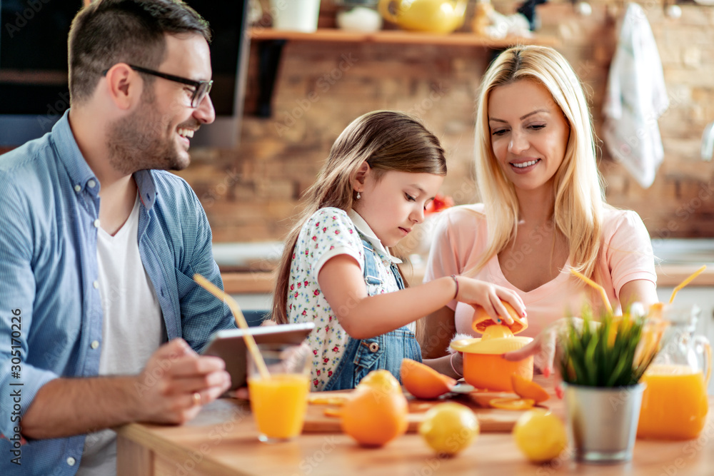 Cheerful young family drinking orange juice Cheerful young family drinking orange juice