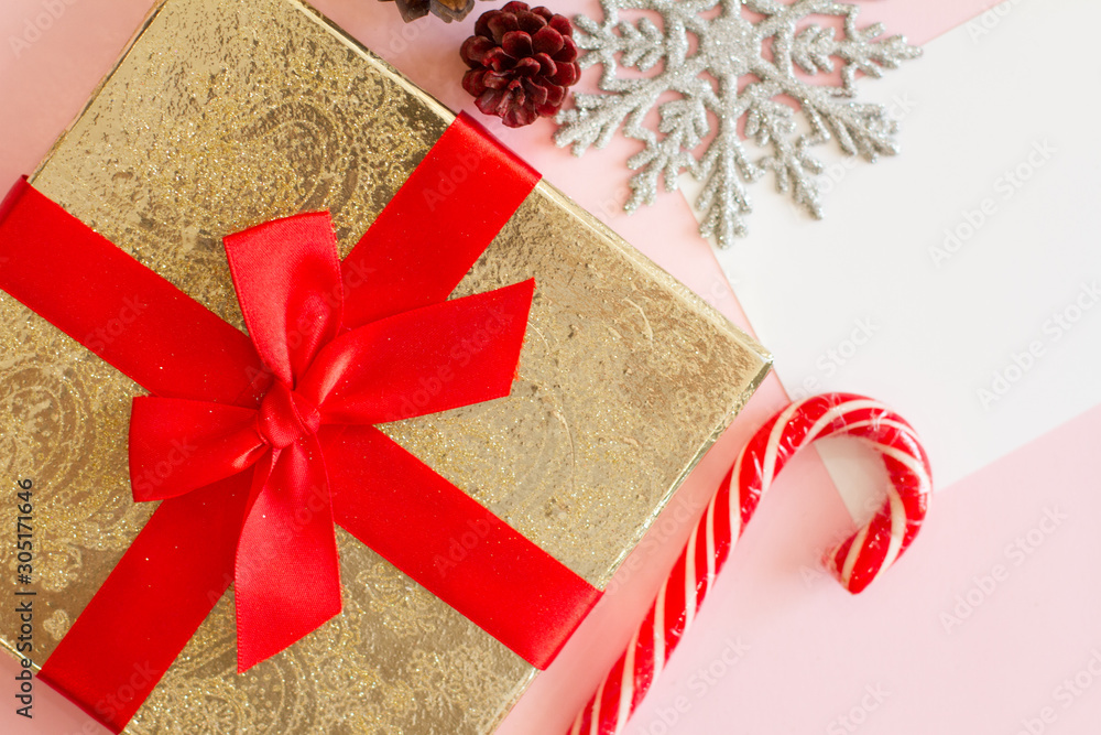 gold box on pink background with red bow. Christmas on the Christmas tree, Christmas candy, snowflake, Golden balls, white paper, letter. cone. christmas present. space for text. Stock | Adobe