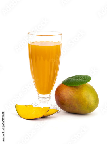 Mango smoothie in high glass served with slided mango isolated on white background. Mango shake shooting in studio. Image with path. Organic tropical fruits on summer concept.